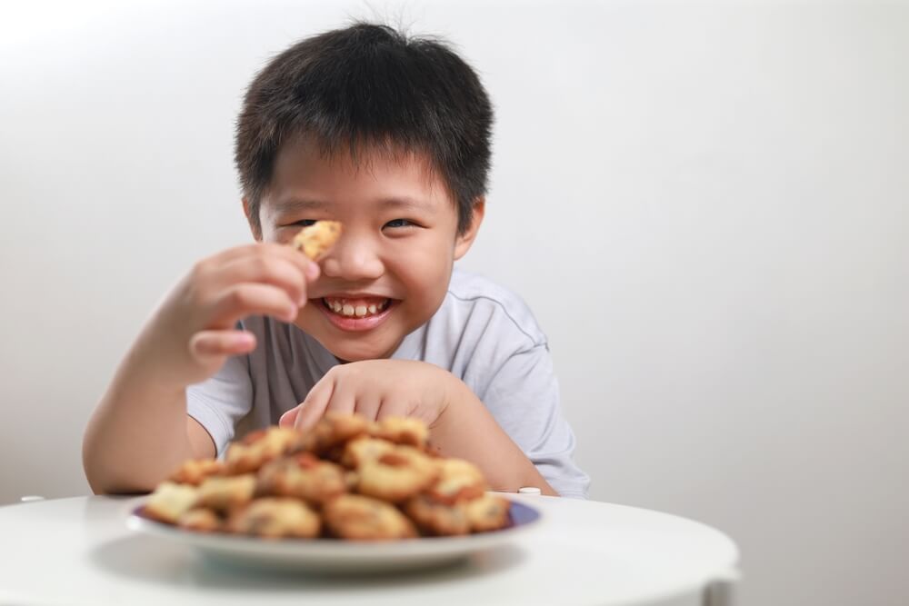 笑顔でクッキーを持つ子ども