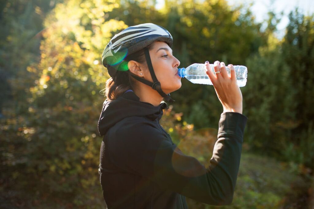 サイクリング中に水分補給をする女性