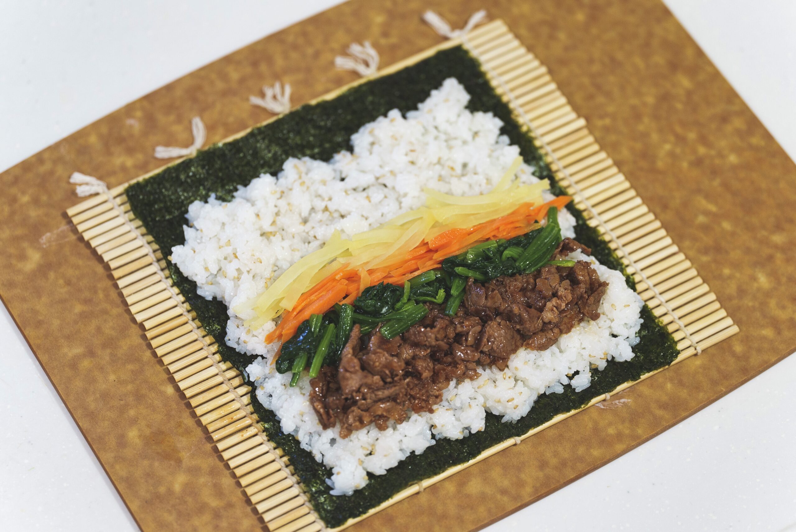 巻きすの上に置かれた海苔と具材