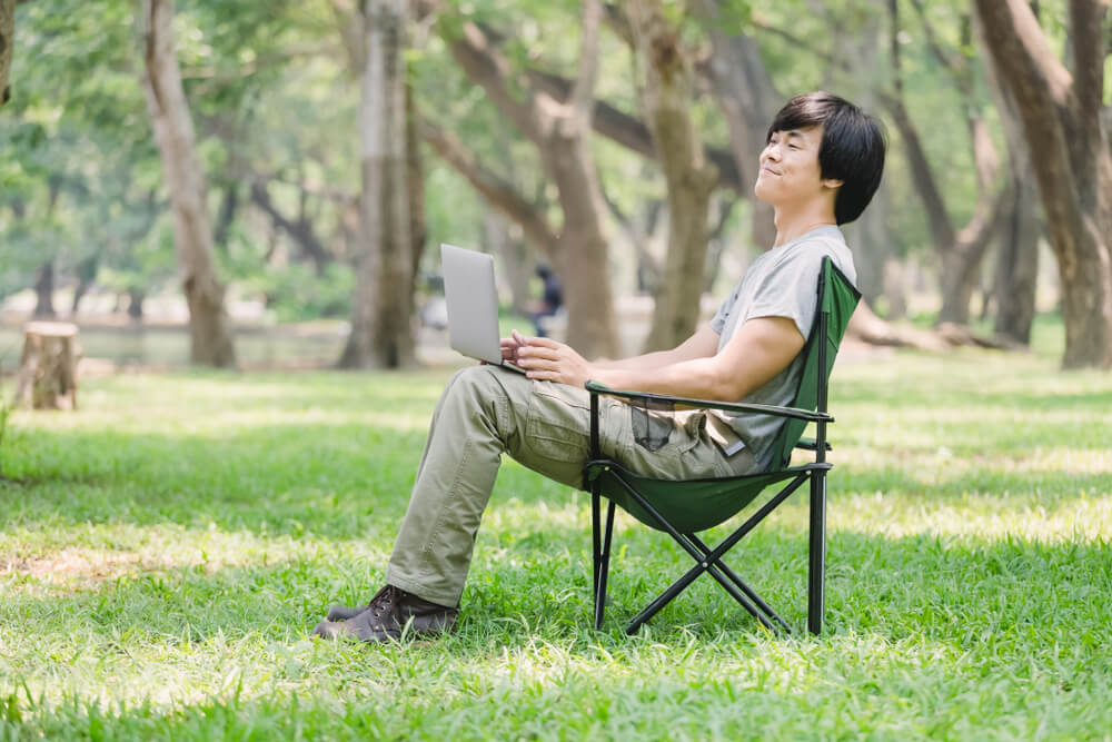 公園でワーケーションをする男性