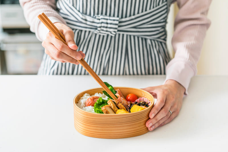 お弁当におかずを詰める女性の手