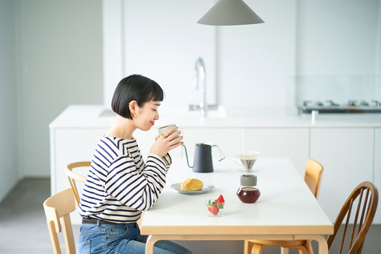 マグカップで飲み物を飲む女性