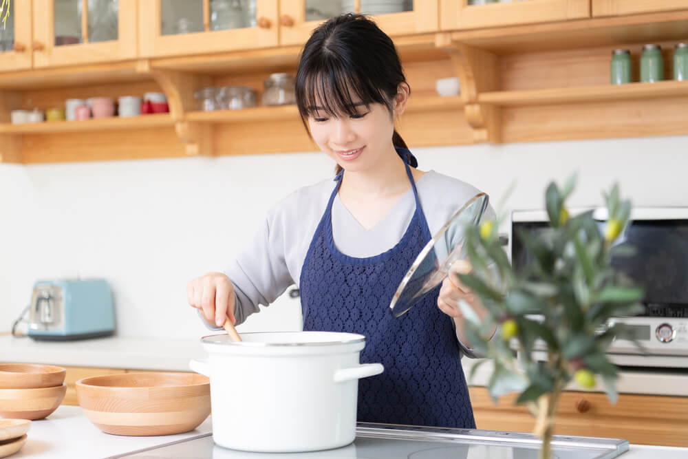 作ったスープを混ぜる女性