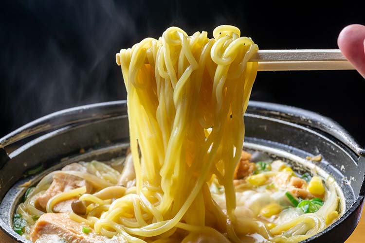 鍋からラーメンをすくう箸