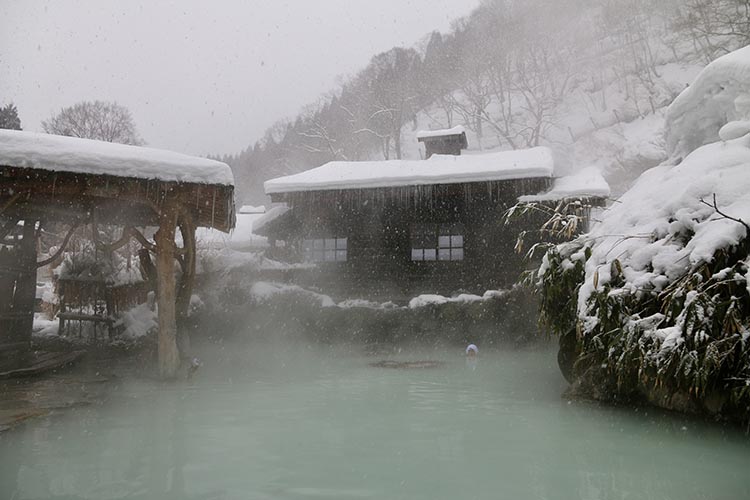 周囲に雪がつもった露天風呂