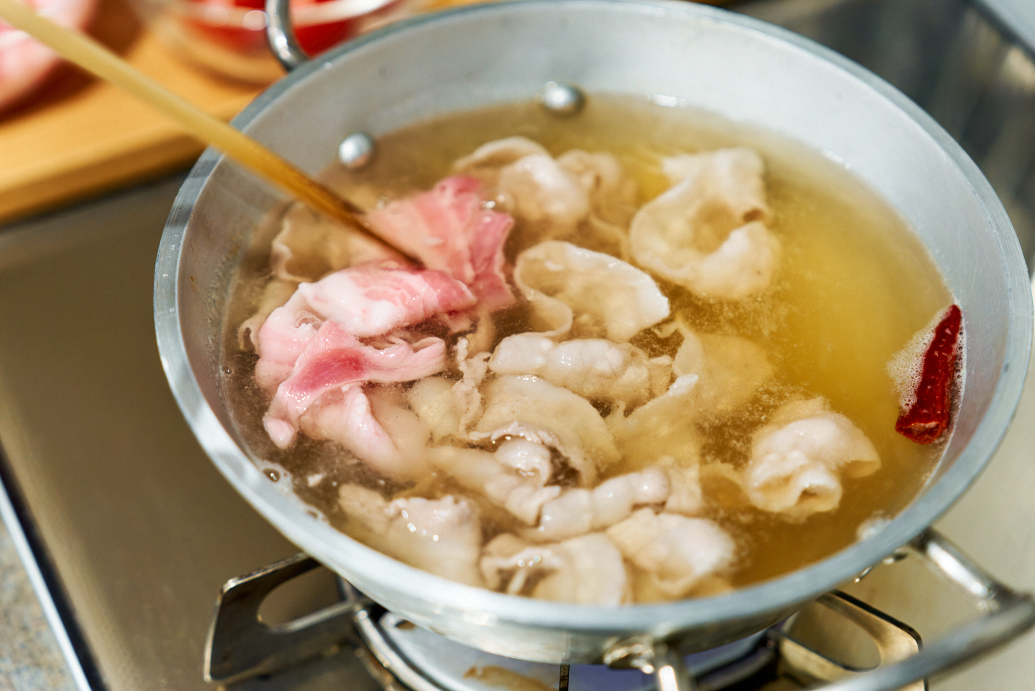 調味料を煮たたせ、豚肉を入れる