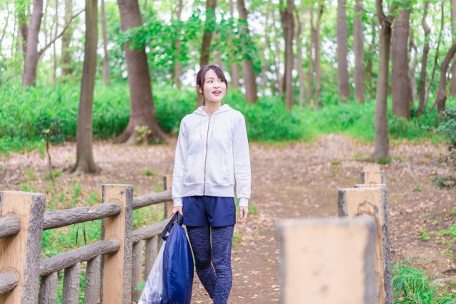 自然に囲まれた緑地を歩く女性