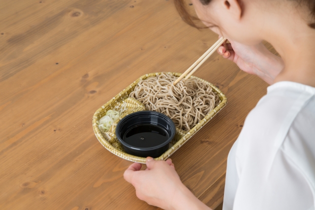 そばを食べようとする女性の後ろ姿