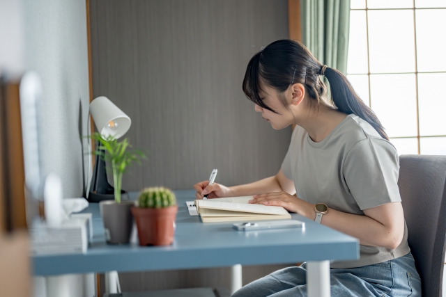 ノートに何かを書く女性