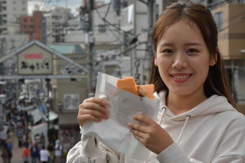 谷中銀座で食べ歩きを楽しむ女性