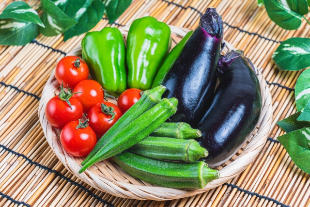 ざるに入った夏野菜　なす　オクラ　トマト　ピーマン