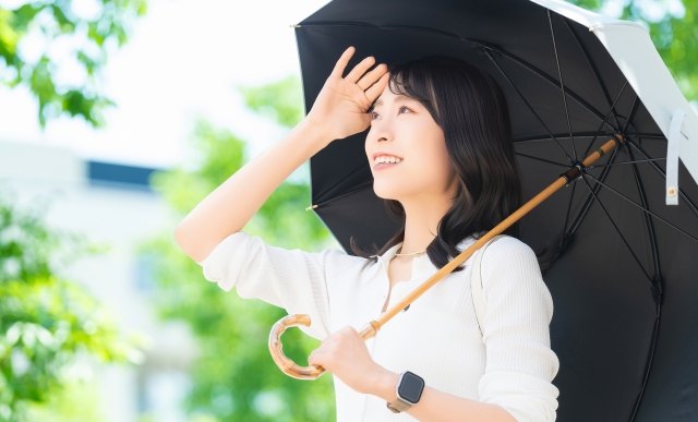内側が黒、外側が白の日傘をさす女性　紫外線　熱中症対策