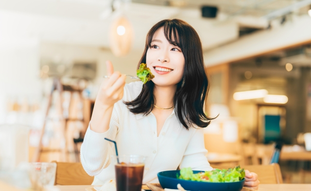 カフェで食事をする笑顔の女性