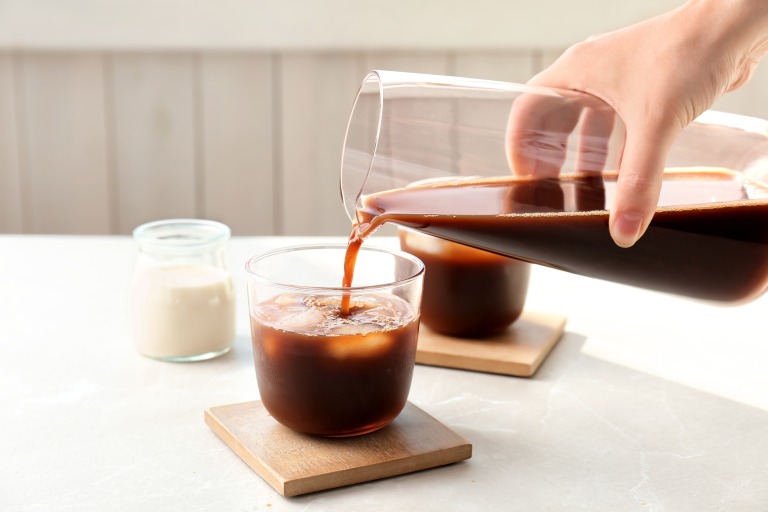 ボトルに入った水出しコーヒーをグラスに注いでいる