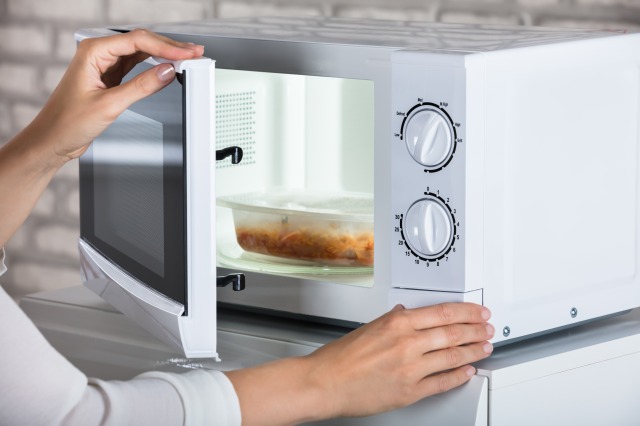 電子レンジで惣菜を温める　人の手元