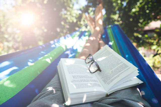 太陽光の下、ハンモックの上で読書