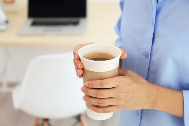 大きいサイズのコーヒーを手にしている女性