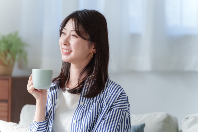 コーヒーを飲む笑顔の女性 