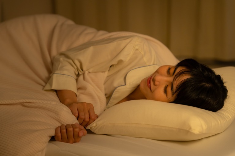 夜に寝る若い女性　快適　笑顔