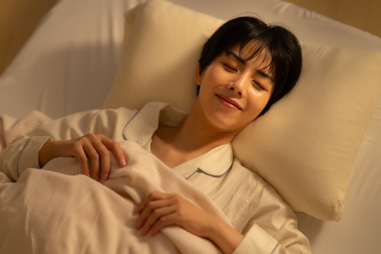 夜に寝る若い女性　快適　笑顔