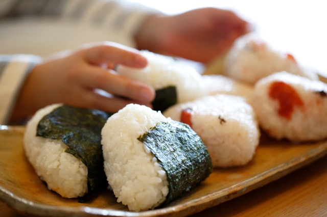 複数のおにぎりと子供の手