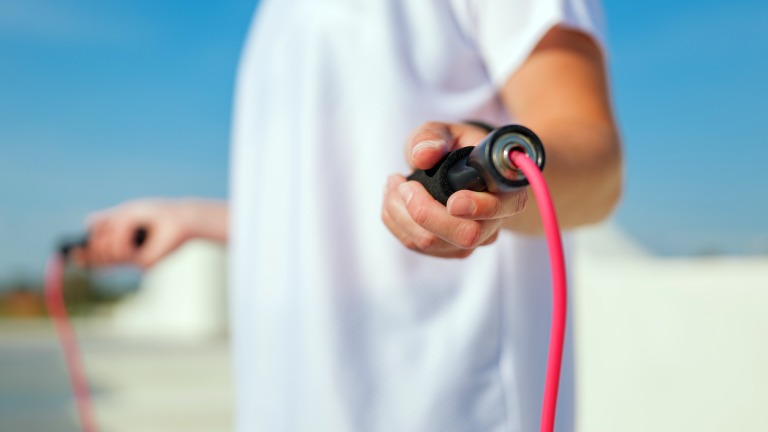 快晴の日に外で縄跳びをする人の手元　運動 エクササイズ　イメージ