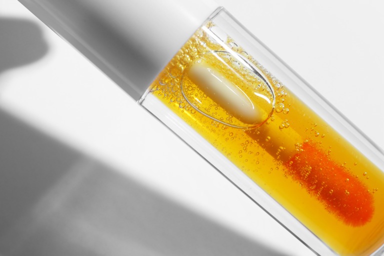 オレンジのリップグロス 白い背景 メイク 化粧アイテム