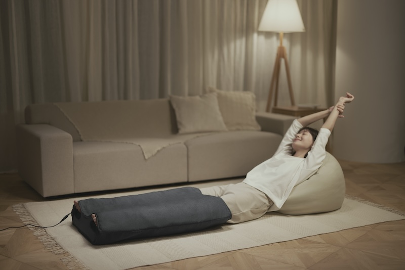 はくだけキュッとリフレを履いてくつろぐ女性　リビング