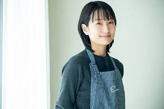 エプロン姿の女性が微笑んでいる様子