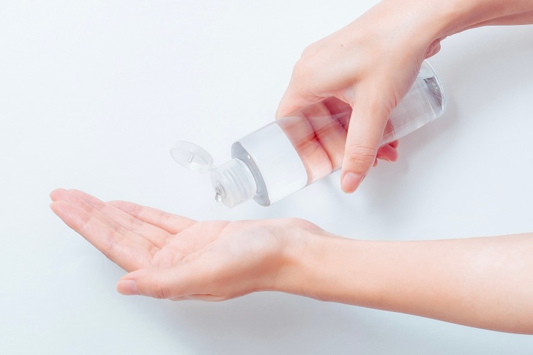 ボディローションのボトルを持って、手に出す　美容イメージ