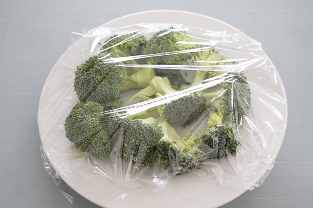 ラップをかけたブロッコリーが入ったお皿　電子レンジ調理イメージ