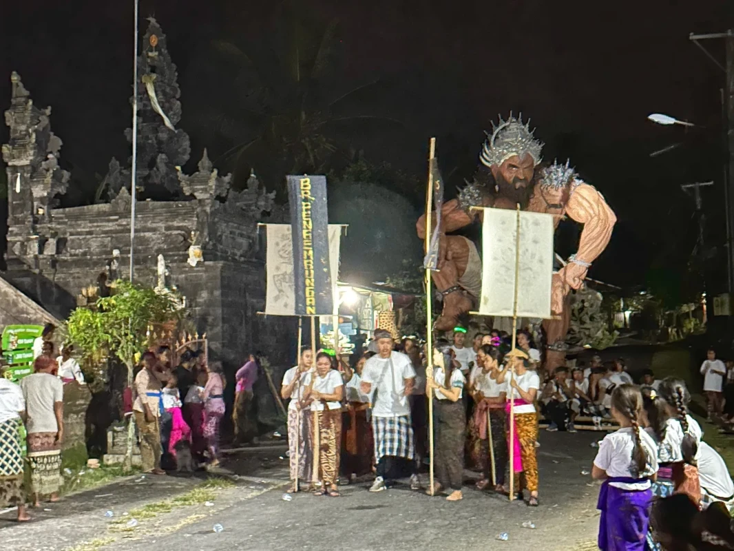 バリ島の夜のお祭り。巨大な像が特徴で、人々が参加しています。