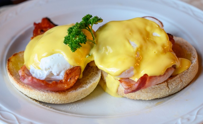 Weekend brunch in Scotland with two eggs benedict on homemade muffuns with roasted bacon and yellow hollandaise sauce. スコットランドの週末ブランチ。自家製マフィンにのせたエッグベネディクト2皿、ローストベーコンと黄色いオランデーズソース添え