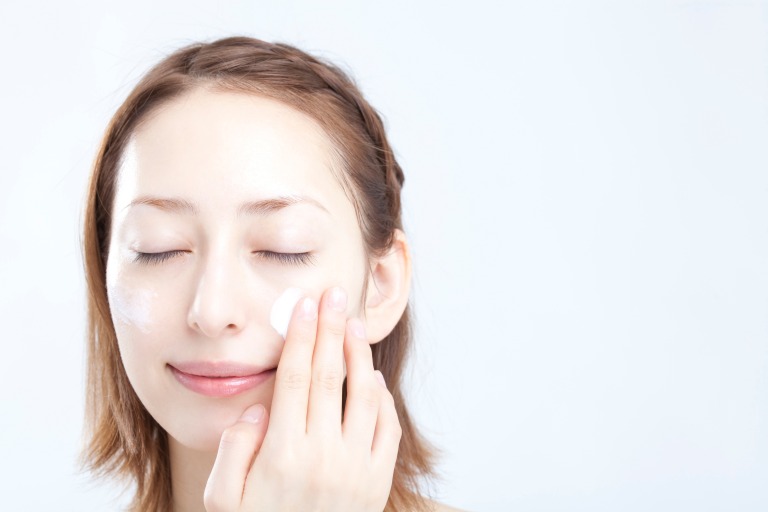 下地クリーム・日焼け止めを顔に塗る女性