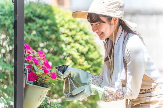 ガーデニング　お花に水をやる笑顔の女性