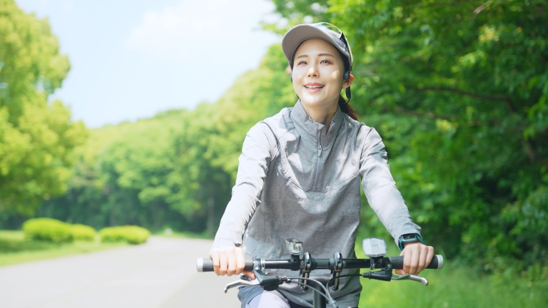 公園で自転車に乗る笑顔の女性 