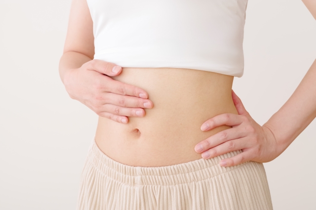 お腹をさする女性の腹部　腸活イメージ