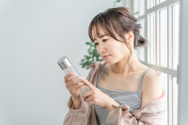 化粧品 ボトルをチェックする女性