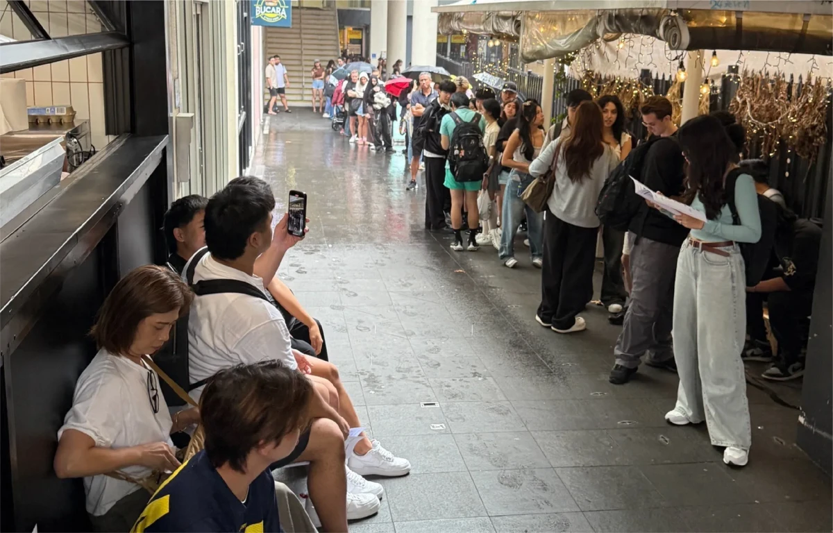 雨の中並ぶ人々
