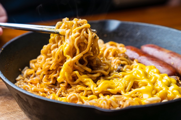 辛ラーメン汁なしアレンジ フライパンにソーセージとチーズと一緒に