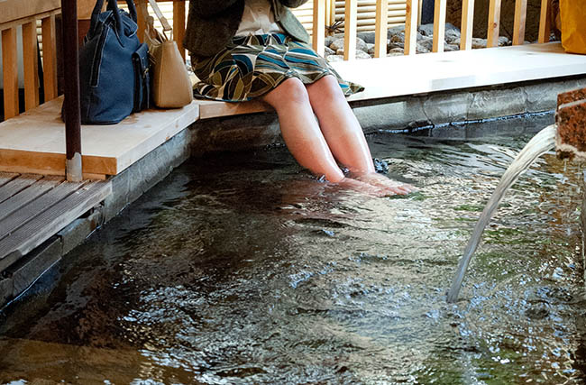 足湯に浸かっている女性の足元