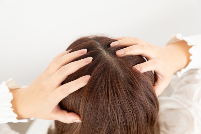 頭皮に両手を置く女性