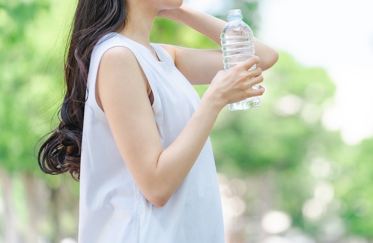 屋外で水分補給する女性