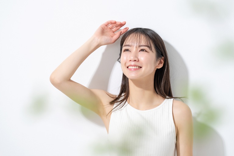 白背景　太陽光を見上げる女性