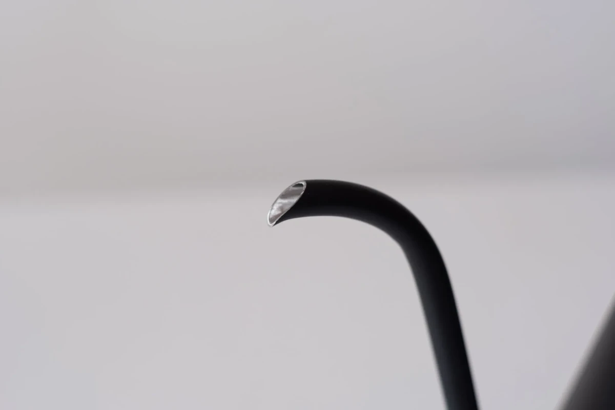 黒いケトルの一部が写った写真。注ぎ口の金属部分が光っている。