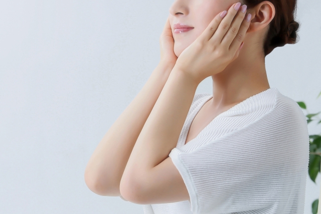 化粧水や下地、日焼け止めを顔にパッティングする女性　美容イメージ