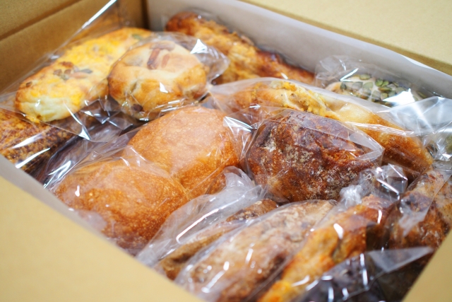 箱に大量に入ったパン　一つずつ袋詰めされている