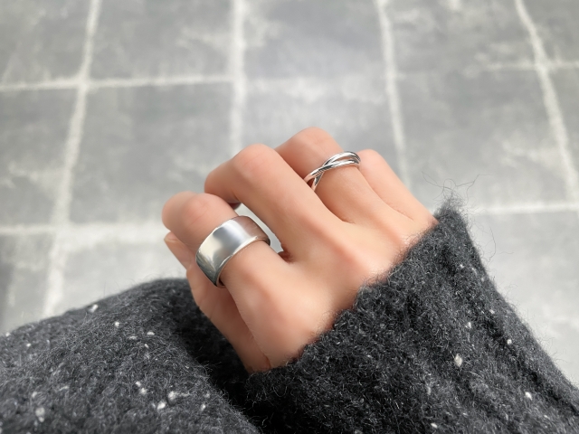 大ぶりと小ぶりのリングを1つずつつけた女性の手元 アクセサリー