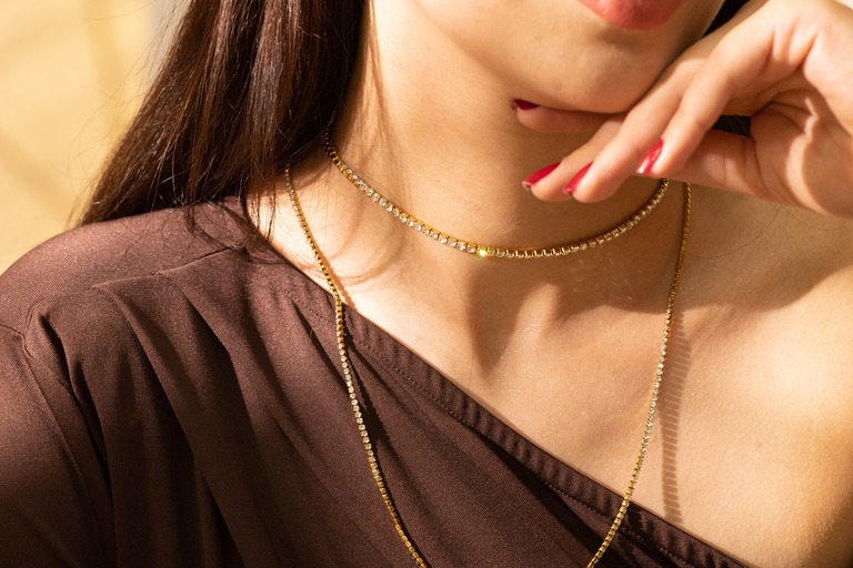 レイヤードのゴールドネックレスをつけた女性