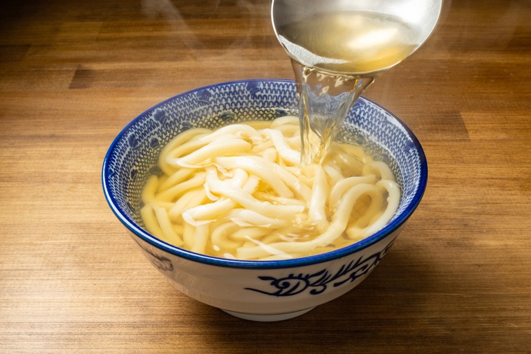 うどんに出汁をかける様子